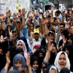 Pakistani Shi'ite people rise their hands as they chant slogans to condemn the Friday's blast at vegetable market in Quetta, during a protest in Karachi,